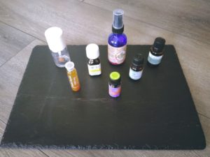 Essential oils, royal jelly, vitamin E oil, rosehip oil on slate.