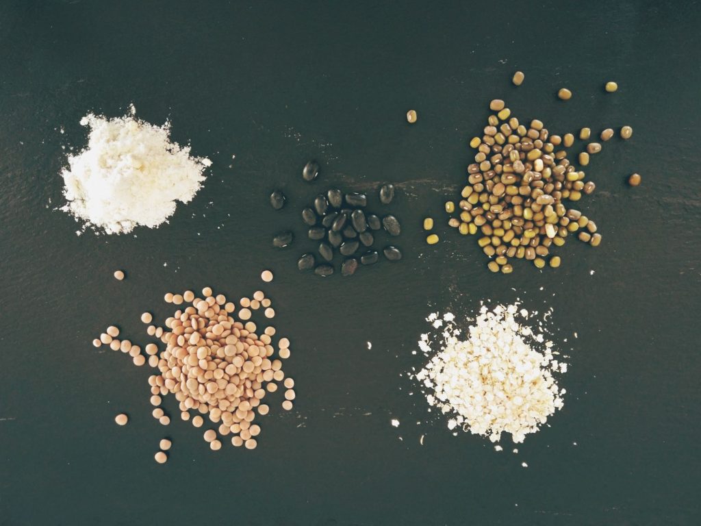 Lentils, quinoa flakes, mung beans, protein powder, and black beans on a slate