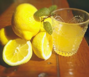 lemons and a glass of organic lemonade sweetened with stevia
