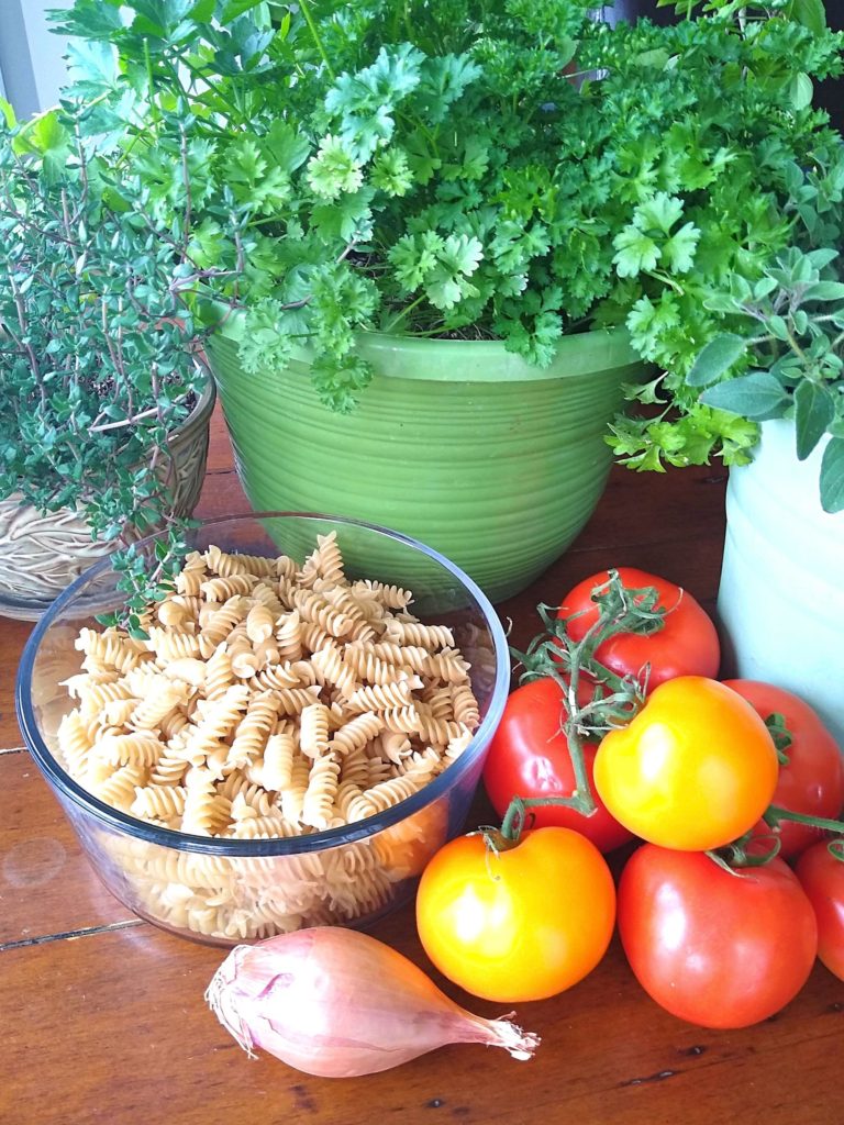 herbs, pasta, and tomatoes with a shallot